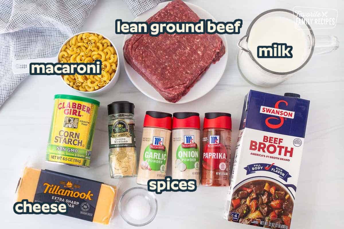 Ingredients to make homemade hamburger helper including ground beef, milk, beef broth, paprika, onion powder, garlic powder, ground mustard, cornstarch, macaroni pasta, salt, and extra sharp cheddar cheese.