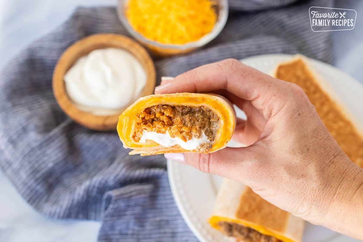 Hand holding a half of a copycat quesarito.