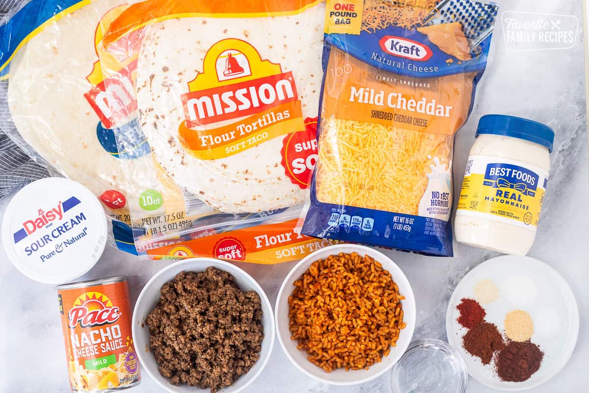 Ingredients to make copycat quesarito recipe including seasoned rice, seasoned ground beef, Nacho cheese, chipotle sauce seasonings, mayonnaise, vinegar, cheddar cheese, sour cream, burrito and soft taco sized tortillas.