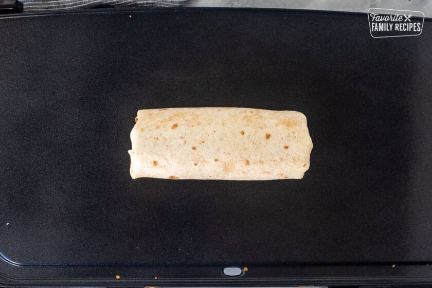 Rolled up quesarito on a skillet.