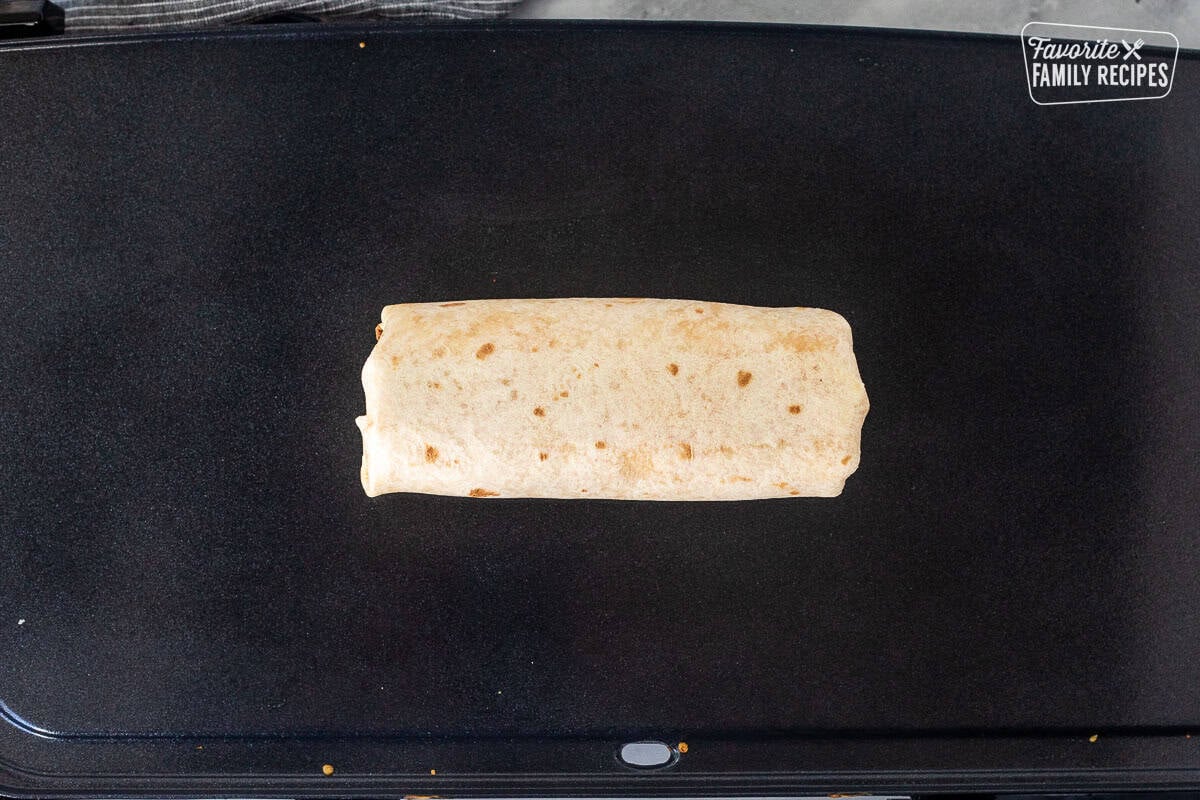Rolled up quesarito on a skillet.