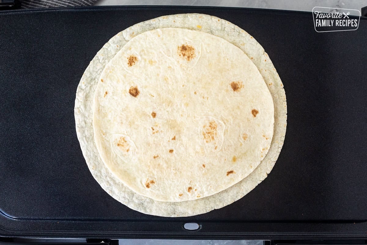 Skillet with tortilla topped with cheese and second tortilla.