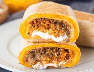 Two halves of a copycat quesarito stacked on top of each other on a plate.