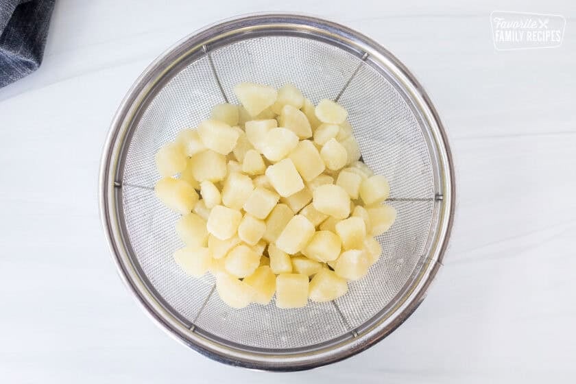 Potatoes draining in a colander to make corn chowder