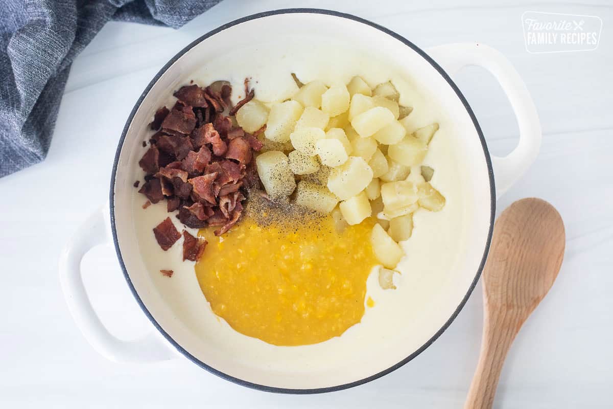 Bacon, potatoes, and corn added to roux in a pot for corn chowder