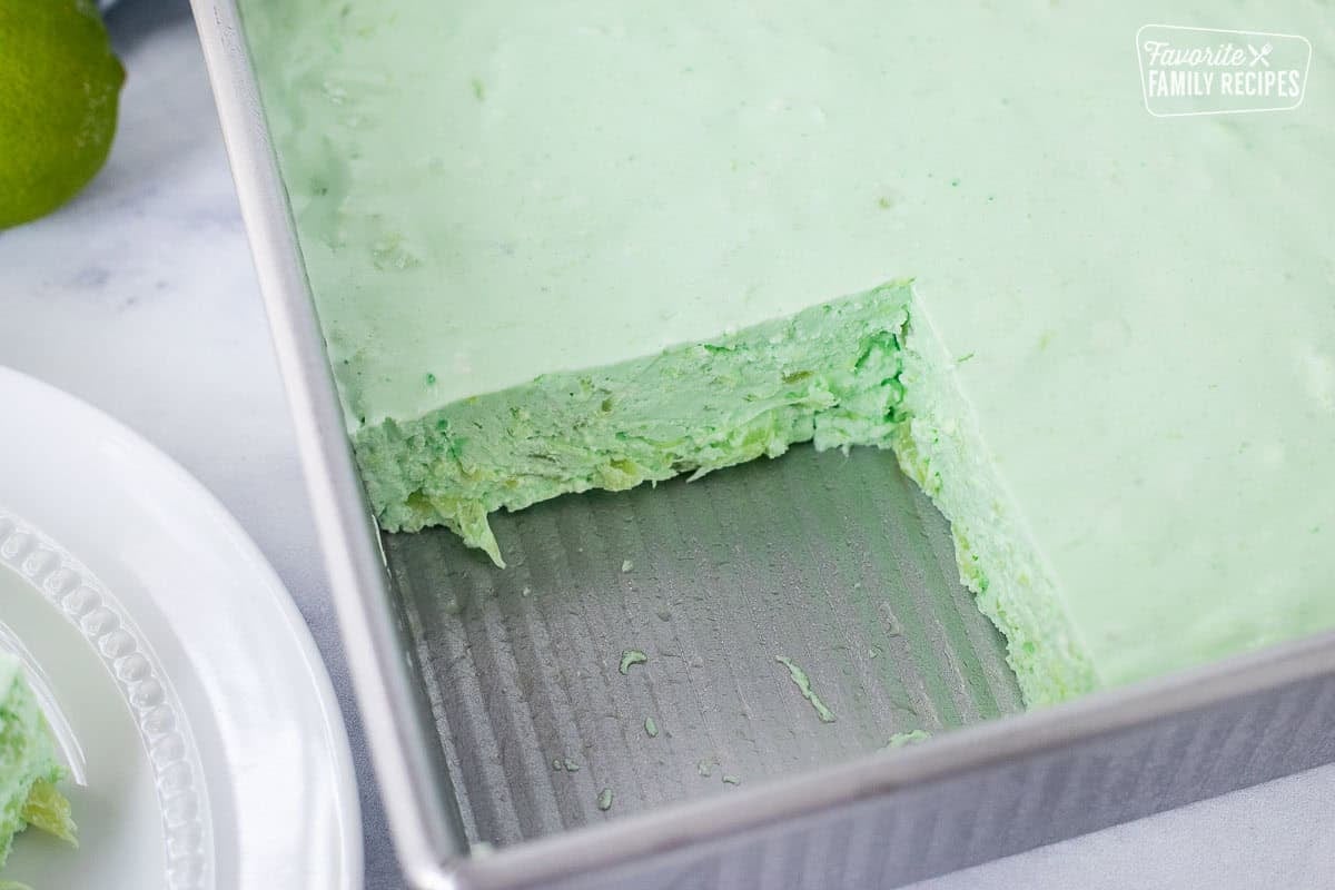 Pan of lime Jello salad missing a slice.