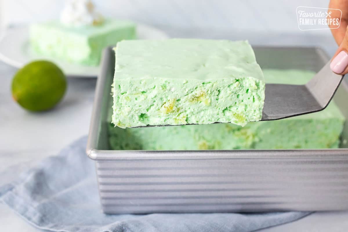 Spatula with a cut piece of lime Jello salad.