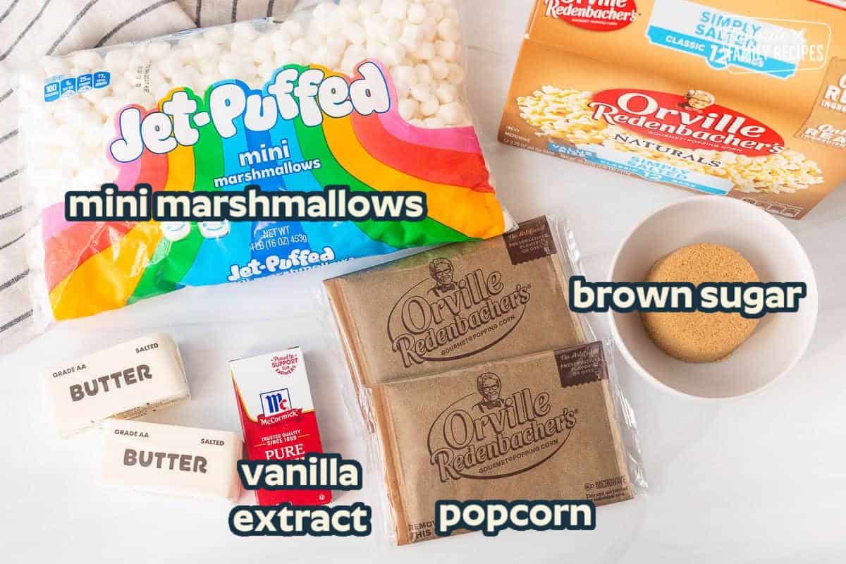 Ingredients to make marshmallow popcorn including simply salted popcorn bags, brown sugar, vanilla, butter and mini marshmallows.