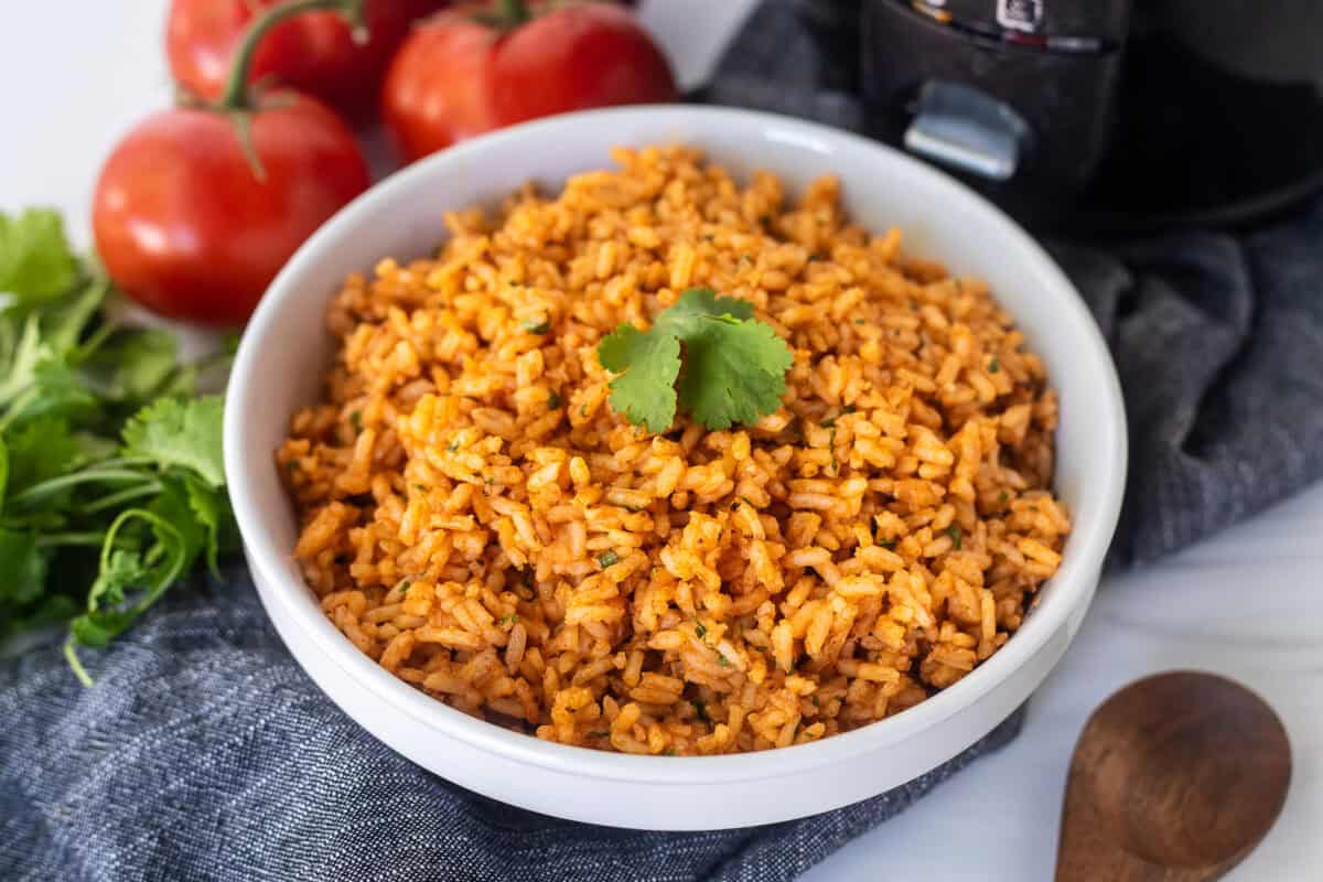 Rice cooker Mexican rice in a bowl and garnished with cilantro.