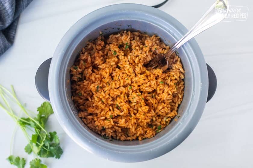 Mexican Rice in a rice cooker and a fork.
