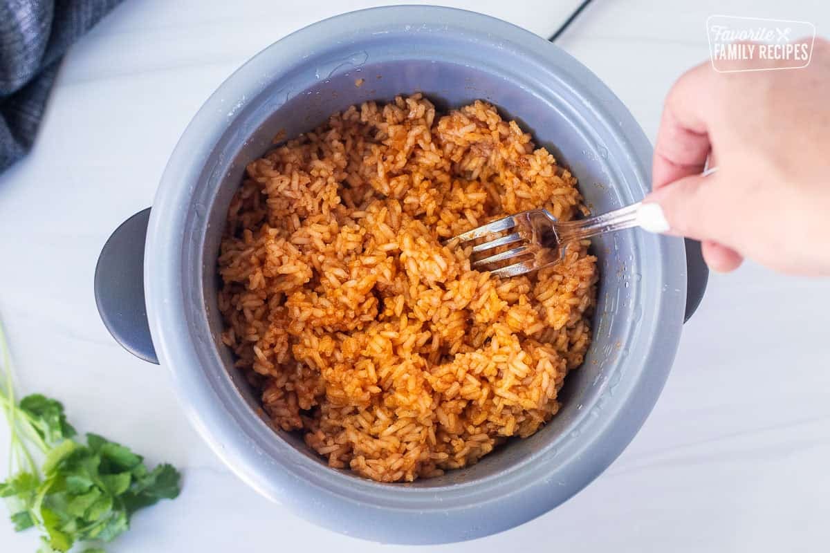 Fluffing Mexican rice with a fork.