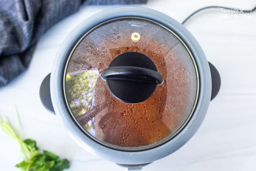 Mexican rice cooking in the rice cooker with condensation on the lid.