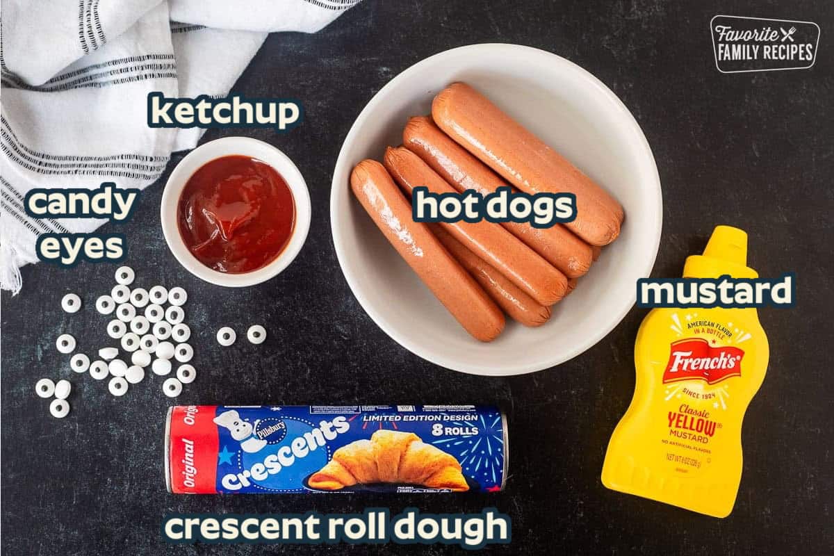 Ingredients to make mummy hot dogs: hot dogs, crescent roll dough, candy eyes, ketchup and mustard