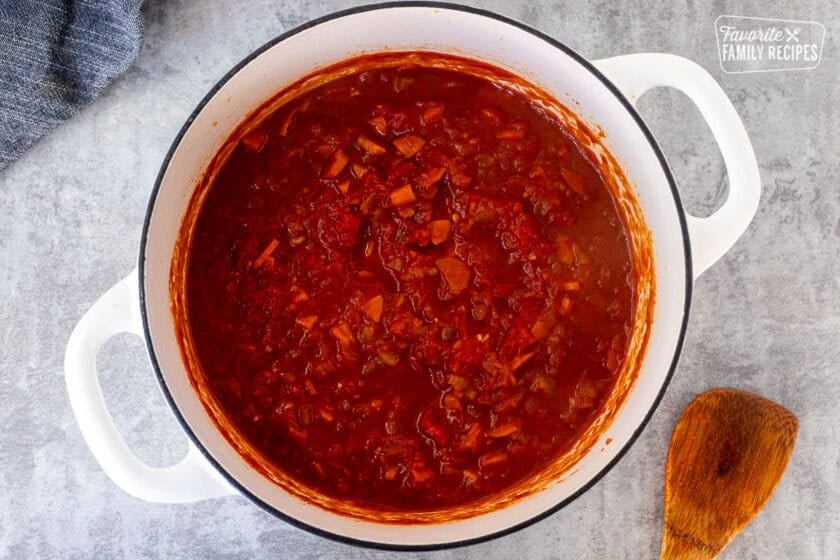 Dutch oven of tomatoes added to ragu sauce.