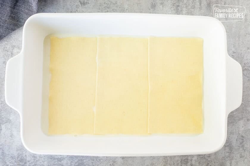 Layer of lasagna noodles in a baking dish.