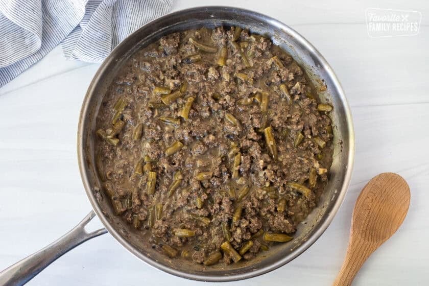 Skillet with ground beef gravy mixture and green beans.