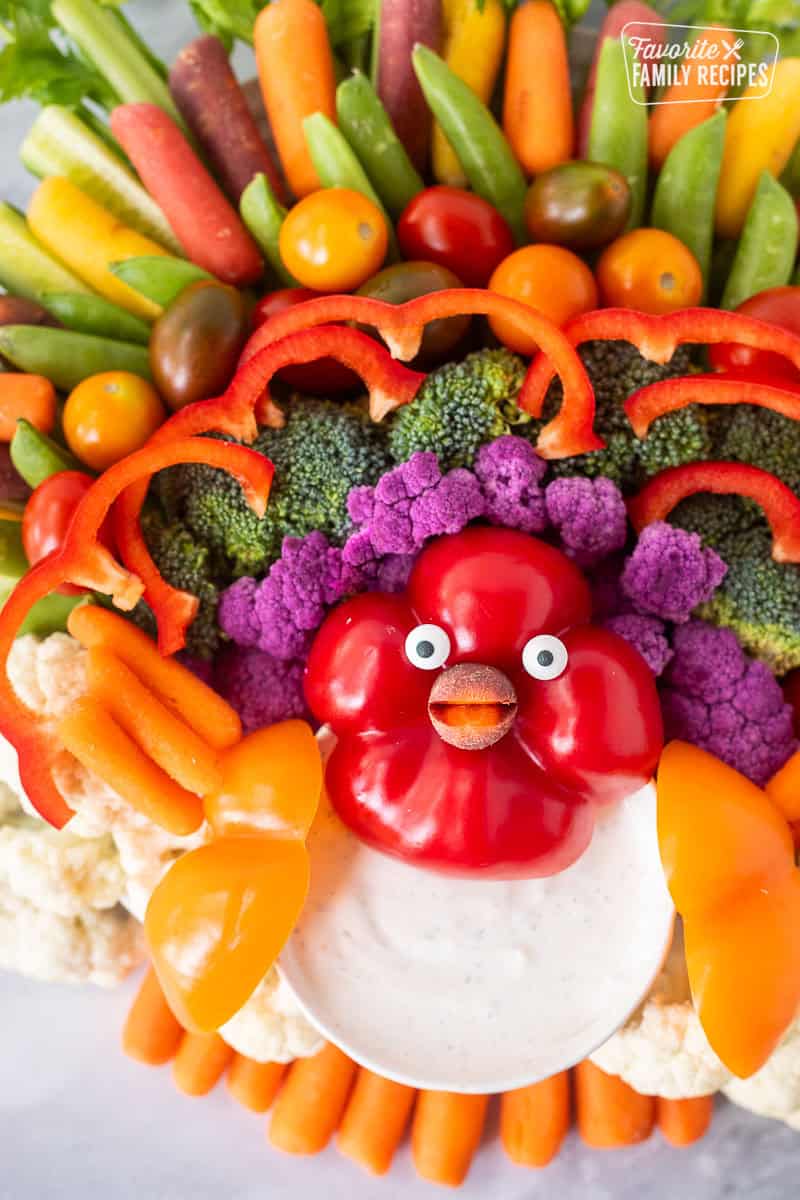 Turkey veggie tray arranged with celery sticks, sliced cucumbers, baby carrots, sugar snap peas, bell peppers, cauliflower, broccoli and tomatoes.