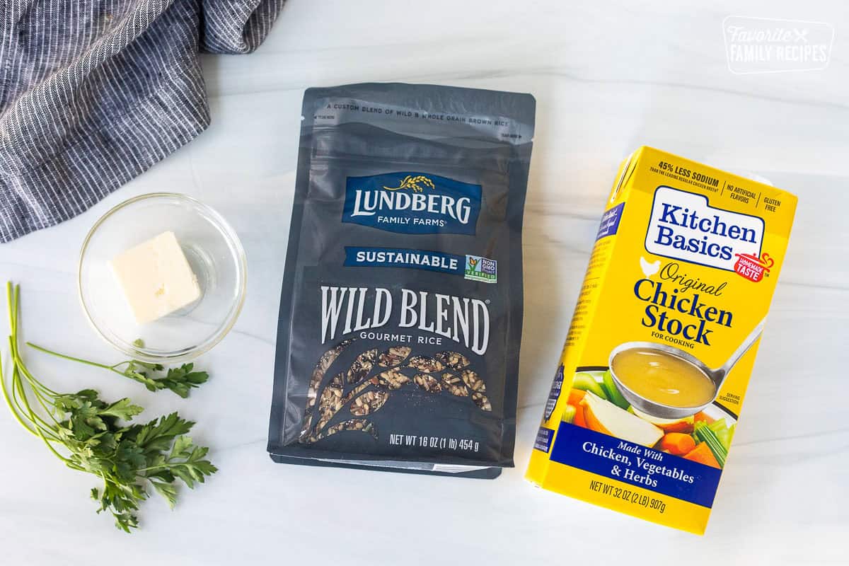 Ingredients to make wild rice including wild rice, chicken stock and butter.