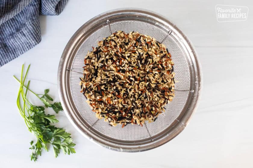 Rinsed wild rice and a colander.