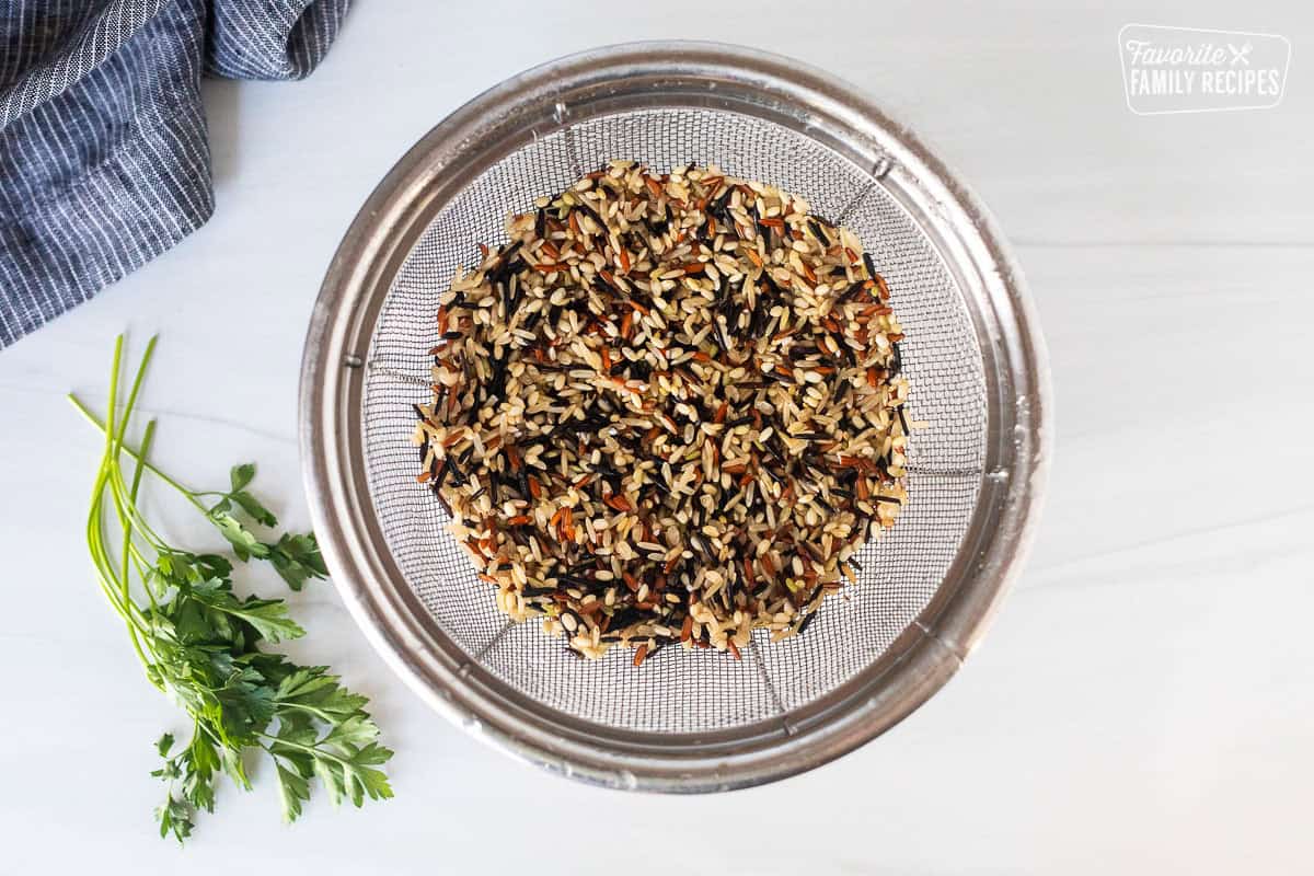 Rinsed wild rice and a colander.