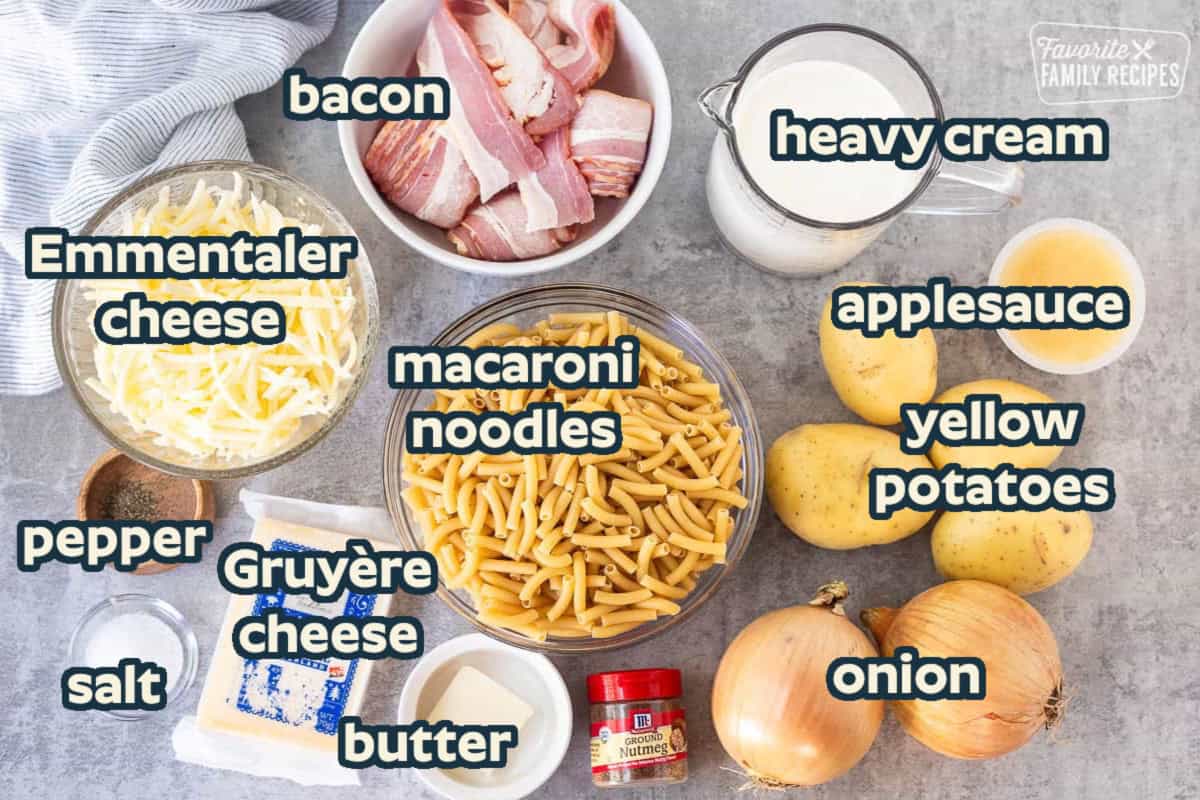 Ingredients to make Alplermagronen including yellow potatoes, cream, onion, nutmeg, butter, Le Gruyere cheese, Emmental cheese, bacon, pasta, salt, pepper and applesauce.