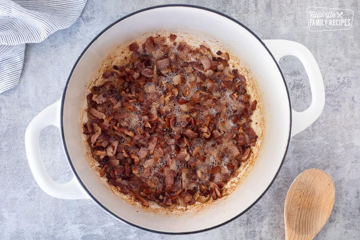 Dutch oven with browned bacon pieces.