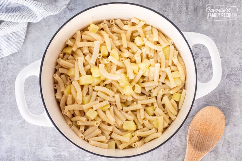 Dutch oven with cooked pasta, potato and cream.
