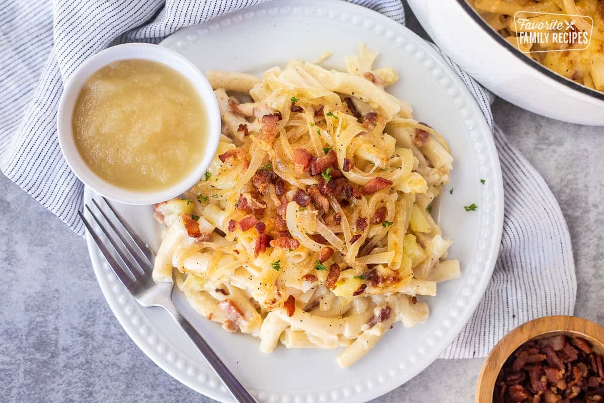 Plate of Alplermagronen with a fork and side of applesauce.