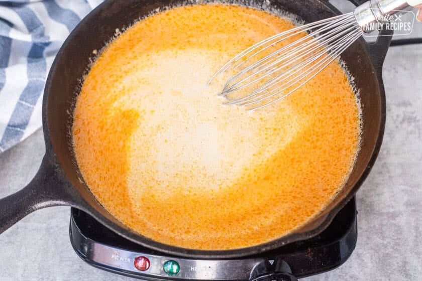 Whisking cream into drippings from chicken cordon bleu.