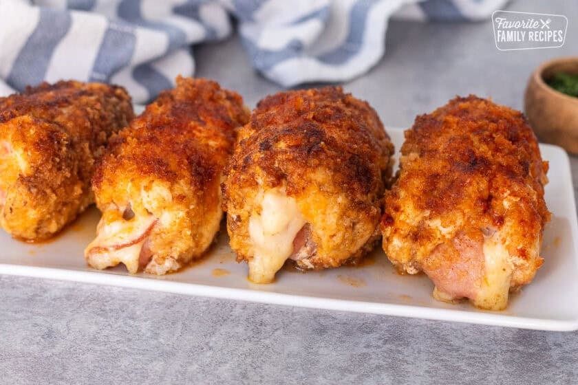 Four pieces of chicken cordon bleu set aside on a plate.