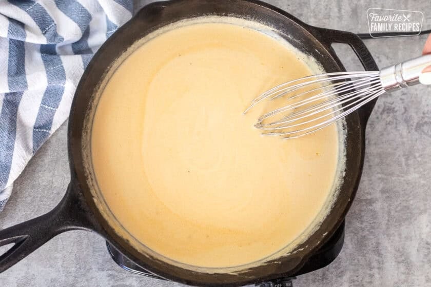 Chicken cordon bleu sauce whisked together in a skillet.