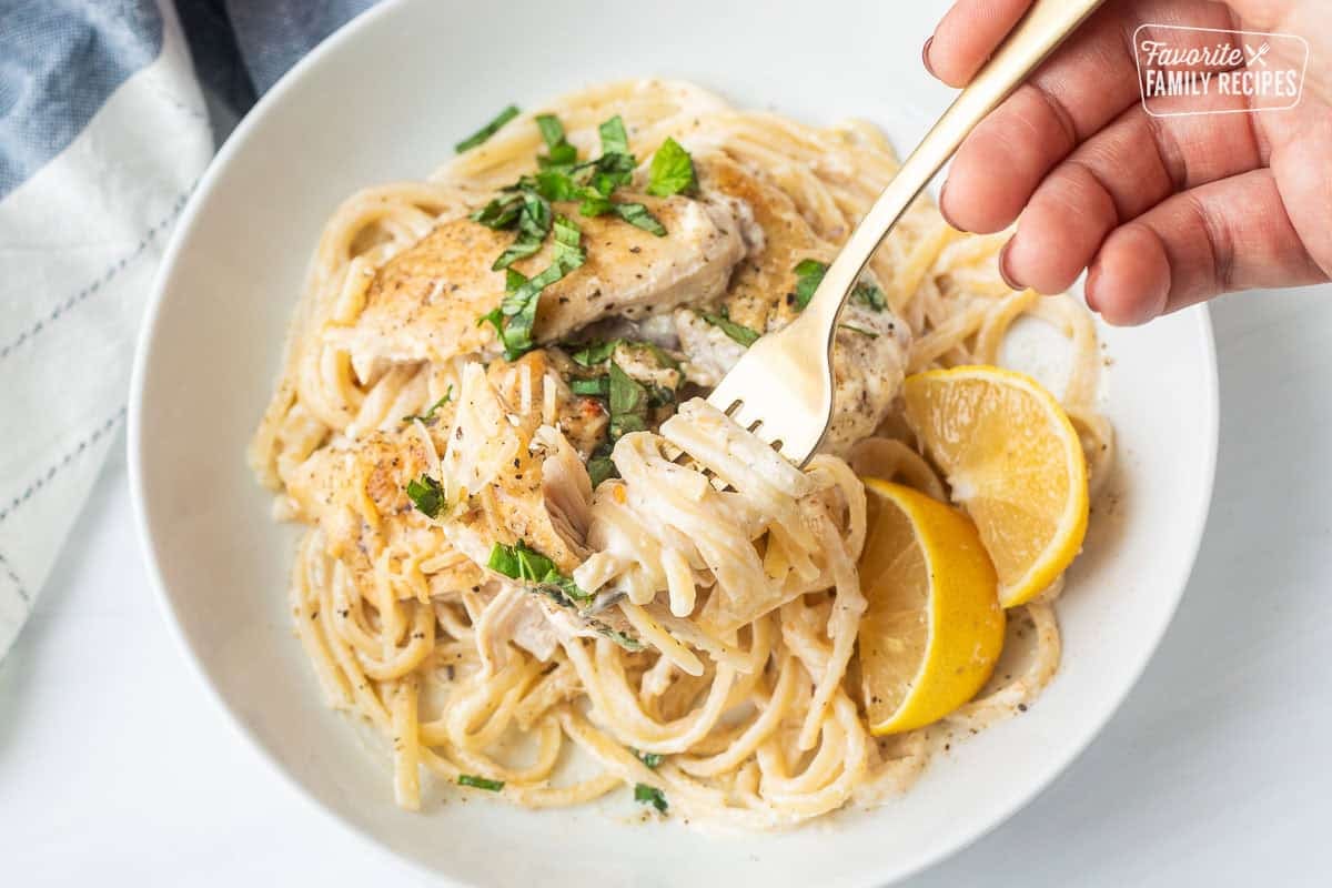 Twirling pasta with Crock Pot Garlic Parmesan Chicken on top.
