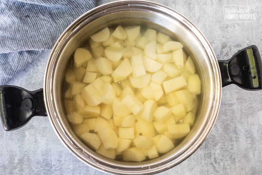 Large pot with boiling potato pieces in water.