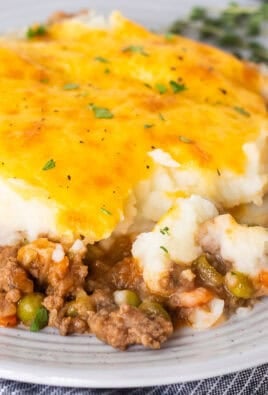 Plate of shepherds pie with a fork removing a corner bite.