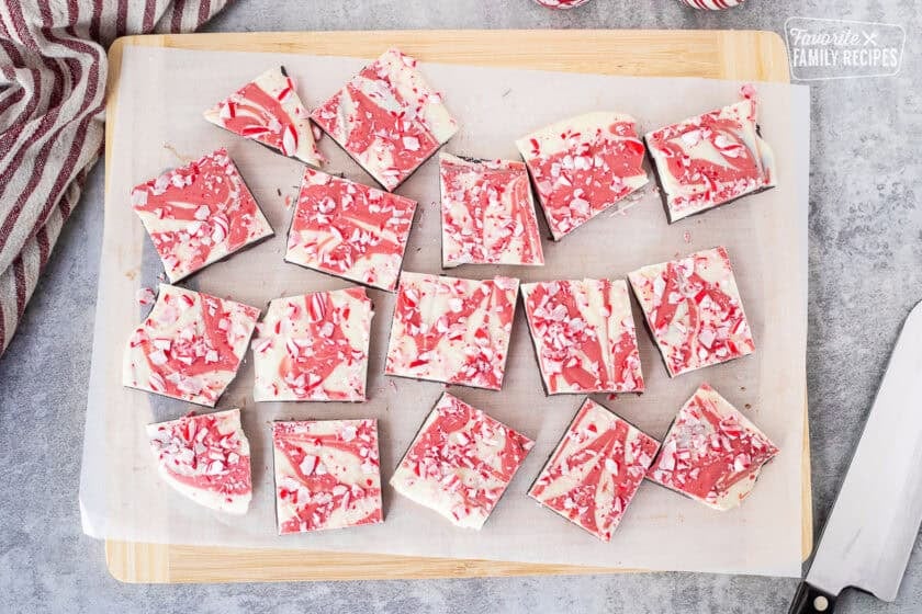 Cut pieces of peppermint bark on a cutting board.
