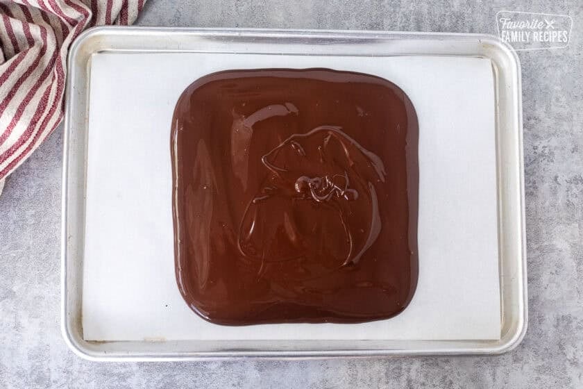 Spread out melted dark chocolate on parchment paper.