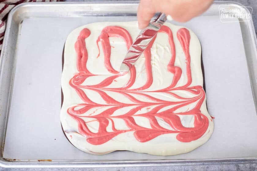 Swirling mint red chocolate into white chocolate layer of peppermint bark.