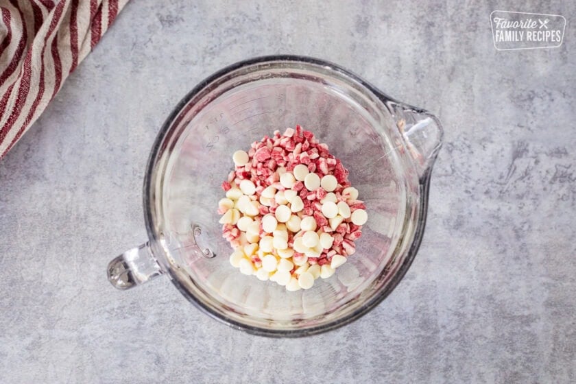Glass bowl with white chocolate chips and peppermint chips.