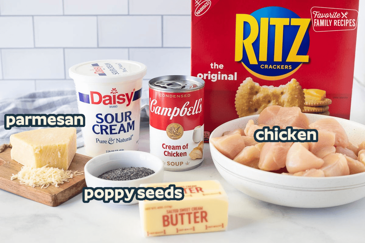 Ingredients to make Poppy Seed Chicken including Ritz crackers, cream of chicken soup, chicken, butter, sour cream, poppy seeds and grated parmesan cheese.